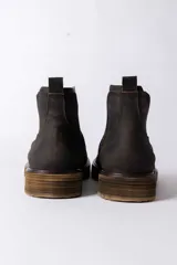 Bota tipo Chelsea de cuero color marrón oscuro, con paneles laterales elásticos y suela de goma con efecto madera.