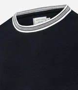 Remera de corte regular confeccionada en tejido texturizado de algodón y poliéster. Presenta cuello redondo y bordes de mangas con detalle de rayas contrastantes en blanco y gris.