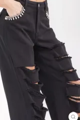 Pantalón jean negro de corte recto semi ancho, con roturas horizontales en ambas piernas y apliques de pedrería brillante en los bolsillos delanteros.
