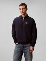 Buzo Calvin Klein azul marino de tejido terry, con cuello alto, cierre frontal parcial con cremallera, mangas largas, puños y ruedo acanalados. Cuenta con el logo de la marca bordado en el pecho.