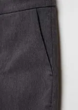 Pantalon de vestir corte skinny, color gris oscuro, con tiro medio, bolsillos laterales y cierre frontal con cremallera y botón.