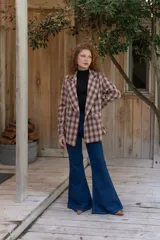 Jeans de corte flare color azul oscuro, tiro alto y diseño ajustado en las piernas que se ensancha gradualmente desde las rodillas hacia el dobladillo.