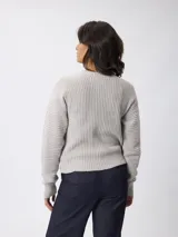 Sweater de tejido acanalado con cuello redondo y manga larga. Presenta un corte relajado y textura estructurada.