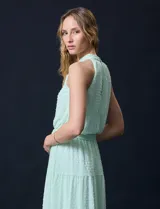 Vestido largo de gasa color verde menta, marca Julia Jordan. Tiene escote halter, cintura elastizada con lazo de ajuste y abertura central en la espalda con botones.