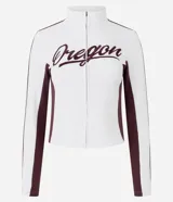 Campera deportiva de corte ajustado, color blanco con paneles laterales y detalles en mangas color bordó. Presenta cierre frontal completo, cuello alto y estampa con lettering 'Oregon' en el pecho.