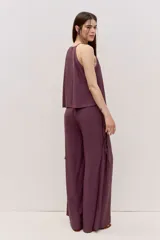 Pantalón de calce amplio y caída suelta, color bordó, con cintura alta y detalle de tiras laterales. Su silueta es oxford.