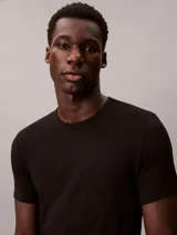 Pack de tres remeras de cuello redondo y manga corta, confeccionadas en una mezcla de algodón, poliéster y elastano. Incluye una remera roja, una blanca y una negra, todas con el logo de Calvin Klein bordado en el bajo.