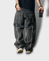 Pantalón jean gris oscuro con efecto lavado y corte mega baggy. Presenta detalles desflecados en la parte trasera de las piernas.