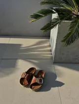 Sandalias de cuero color marrón con hebilla dorada y plantilla de cuero.