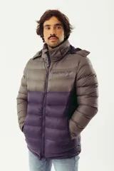 Campera puffer de abrigo con diseño bicolor, gris en la parte superior y violeta oscuro en la inferior. Cuenta con cierre frontal completo, capucha desmontable, bolsillos laterales con cierre y logo estampado en el pecho.