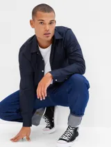 Camisa de corte slim confeccionada en popelina, con cuello clásico, cierre frontal de botones y manga larga con puños abotonados.