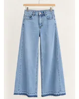Jean de denim celeste claro, de tiro medio y corte wide leg con botamanga desflecada.
