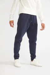 Pantalón deportivo de invierno con frisa, color negro, de corte regular. Cuenta con cintura elástica con cordón ajustable, bolsillos laterales y logo estampado en la pierna izquierda.