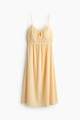 Vestido midi de algodón con textura efecto arrugado, color amarillo, tirantes finos ajustables, escote corazón con abertura tipo cerradura y lazo frontal, cintura elástica fruncida y falda evasé con vuelo ligero.