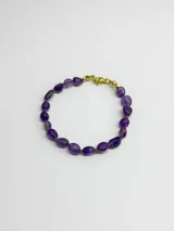 Pulsera de piedras naturales en tonos violeta y morado, con cierre de mosquetón metálico en tono dorado.