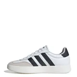 Championes urbanos Adidas modelo Barreda, de silueta baja y estilo clásico inspirado en el tenis. Presentan una capellada de cuero sintético blanco con refuerzos de gamuza en la puntera, las icónicas tres tiras laterales en color negro y suela cupsole de goma.