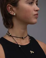 Aros pequeños de bronce con forma irregular y acabado liso, estilo huggie o argolla gruesa.