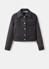Chaqueta de denim en color negro, de corte clásico con cierre frontal de botones metálicos, cuello camisero y bolsillos con solapa en el pecho.