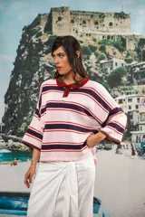 Remera rosa con rayas horizontales azul marino y bordó, cuello tipo polo marrón con botones y mangas cortas amplias.