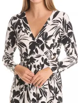 Vestido envolvente de seda fría estampado en blanco y negro, marca Luxology. Presenta escote en V cruzado, cintura elastizada con apliques metálicos en el lateral, manga larga entallada y ruedo asimétrico en el frente.
