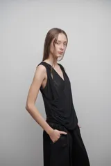 Blusa negra de microtul doble, con escote cruzado en V y drapeado suave. Diseño liviano y translúcido.