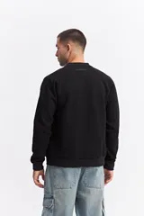 Campera tipo bomber color beige, con cierre frontal completo, cuello redondo y puños elásticos. Presenta una textura sutil en la tela y un calce cómodo.