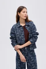 Campera de denim azul con estampado estilo paisley, cierre frontal con botones metálicos y cuello camisero.