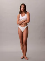 Colaless blanco de algodón con textura de canalé fino y cintura elástica con logo Calvin Klein. Corte ajustado con pierna alta y cobertura mínima.