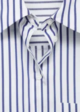Camisa crop de corte recto confeccionada en mezcla de algodón, poliéster y viscosa. Presenta diseño de rayas verticales en azul y blanco, cuello camisero, bolsillo aplicado en el pecho y cierre delantero con botones.