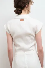 Camisa color beige claro de lino, con cuello clásico, abotonada al frente y sin mangas.