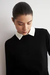 Sweater clásico de punto color beige, de cuello redondo y manga larga con diseño ajustado.