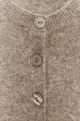 Chaqueta de punto de cuello redondo y manga larga, con cierre frontal de botones y acabados en rib.