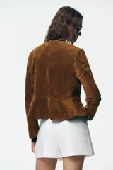 Falda pantalón blanca de tiro alto con cinturón marrón y delantero cruzado. Cierre lateral con cremallera oculta.