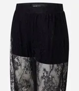 Pantalón de encaje negro con diseño aladín, de corte amplio y fluido con cintura elástica. Presenta una estructura transparente en las piernas y forro corto en la parte superior.