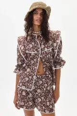 Camisa marrón con estampado floral, cuello con volados y mangas 3/4 con puños elásticos.