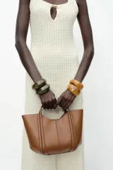 Bolso de mano tipo mini city, color borgoña, con pespuntes en contraste. Presenta asa de mano y asa bandolera extraíble. Incluye una bolsa interior extraíble con cierre de cremallera.