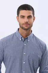 Camisa de manga larga con estampado de cuadros pequeños en tonos rojo, azul y blanco. Presenta cuello abotonado, cierre frontal con botones y un bolsillo pequeño en el pecho.