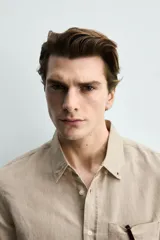 Camisa regular fit de manga larga con diseño a rayas verticales celestes y blancas. Cuenta con cuello abotonado, bolsillo de parche en el pecho y cierre frontal con botones.