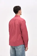 Camisa de corte regular fit confeccionada en algodón, con cuello clásico, cierre frontal de botones y bolsillo en el pecho con detalle bordado.