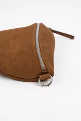 Bandolera tipo riñonera de gamuza color marrón, con cierre principal plateado y tiradores largos. Incluye correa regulable desmontable.