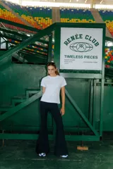 Pantalón Oxford negro de lycra gruesa, con corte acampanado, tiro medio y tajos laterales.