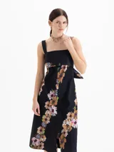 Vestido maxi negro con estampado floral, silueta en A, escote cuadrado con bandeau superpuesto y lazo en la espalda.