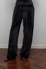Pantalón de terciopelo negro, de corte amplio y relajado, con cintura elástica, botamanga recta y bolsillos laterales.