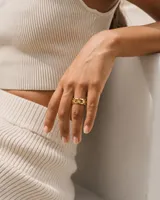 Anillo de acero dorado con diseño geométrico y detalles grabados.