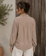 Camisa de diseño clásico con cuello camisero, mangas largas con puño elastizado y cierre de botones al frente.