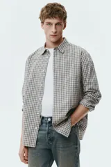 Jean de corte recto en denim de algodón rígido, con diseño de cinco bolsillos y acabado con efecto desgastado.