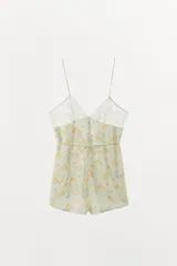 Mono corto de viscosa con estampado floral amarillo sobre fondo verde menta, escote cuadrado con detalles de encaje y tirantes finos.
