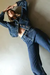 Pantalón de jean azul oscuro, de corte recto y tiro medio, con detalle de ruedo desflecado.