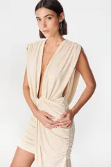 Vestido corto de diseño asimétrico en color verde oliva, con escote profundo en V, drapeado frontal y una caída lateral larga que llega hasta el suelo. Sin mangas y con ajuste entallado en la falda.