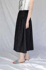 Falda midi de corte amplio con cintura elastizada y frunces laterales, confeccionada en tejido tipo gobelino con estampado floral sobre fondo azul.